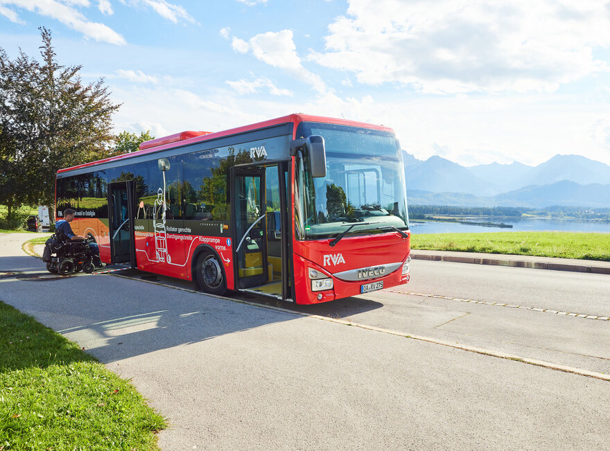 Foto eines Nahverkehrs-Busses mit dem Forggensee und den Ammergauer Alpen im Hintergrund