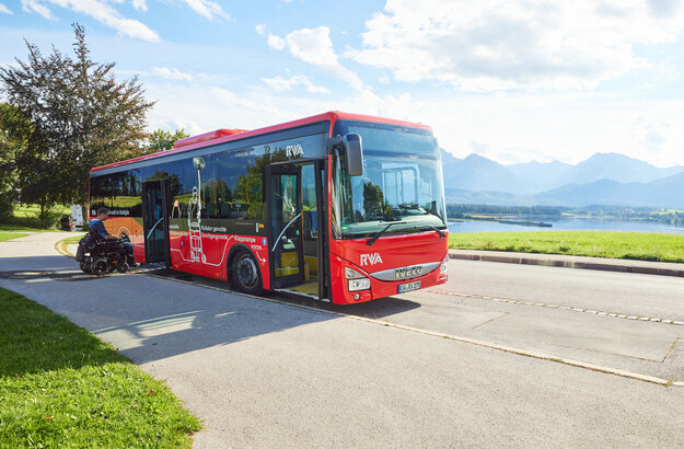 Foto eines Nahverkehrs-Busses mit dem Forggensee und den Ammergauer Alpen im Hintergrund