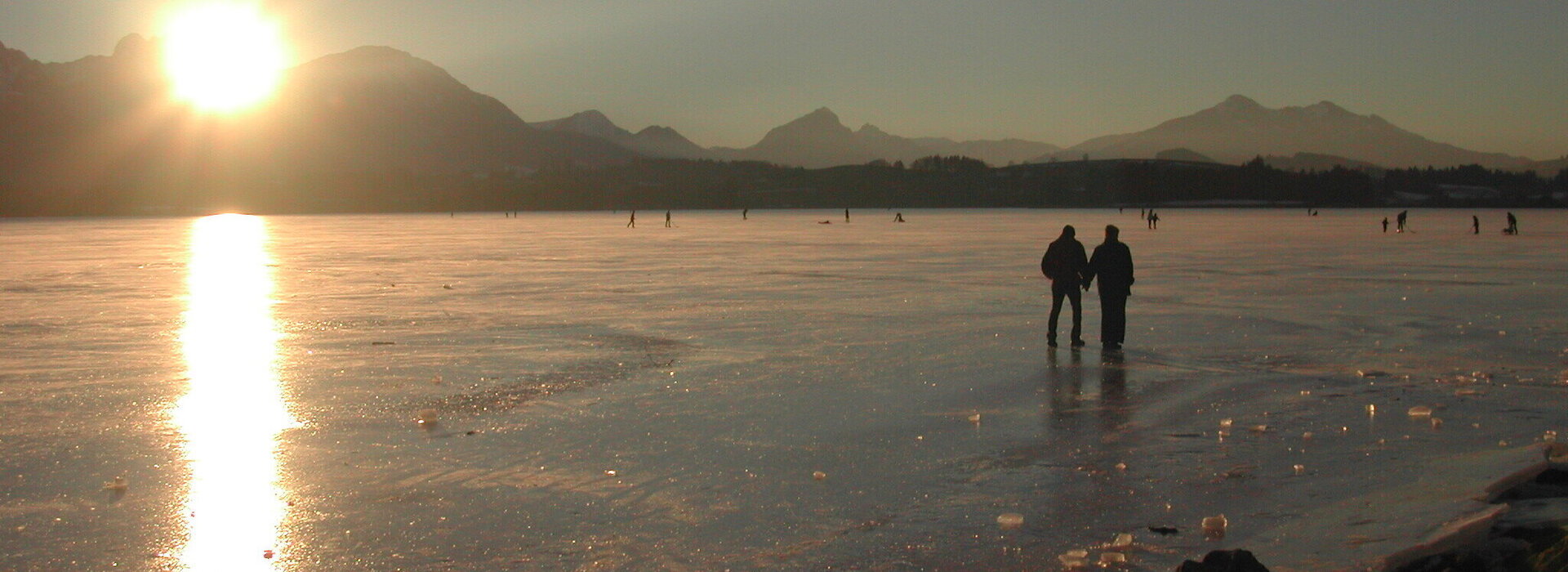 The picture shows the frozen Hopfensee near Füssen in front of the Alpine peaks